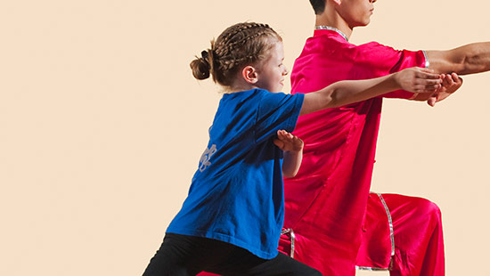 Tai chi practitioner moving through a slow, deliberate form outdoors